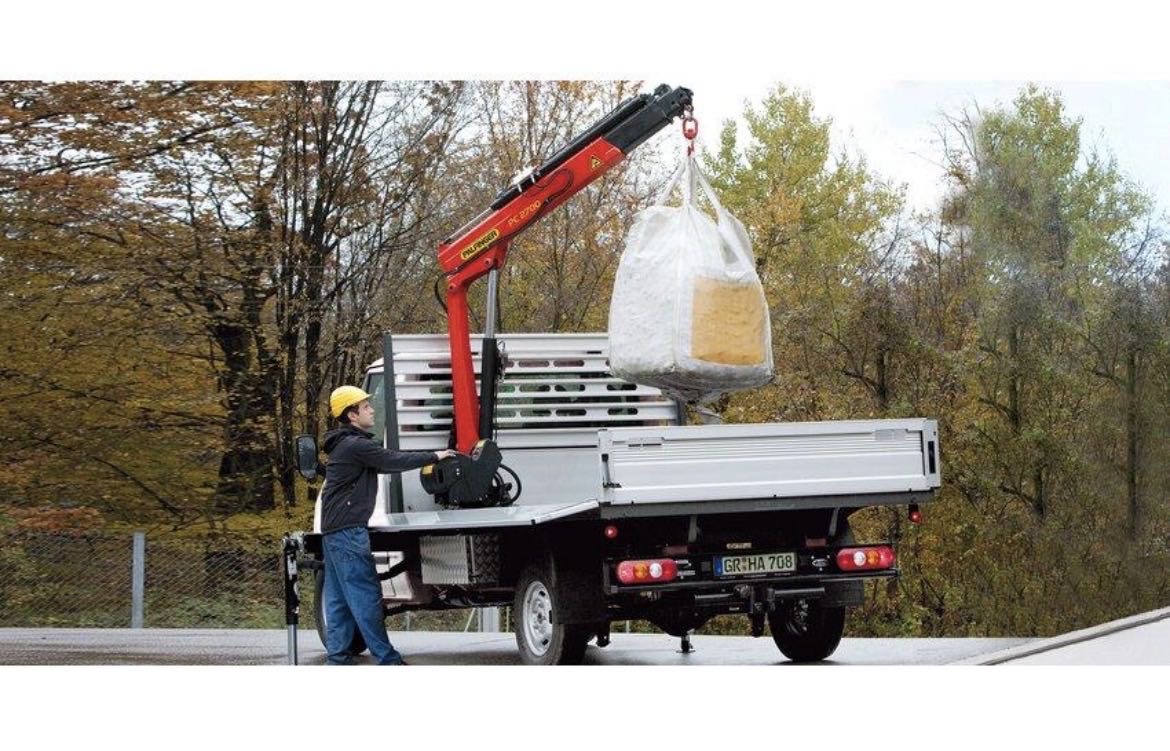Truck-mounted crane lifting a large item